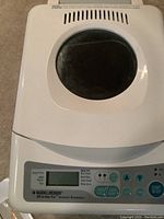 Top view of white Black & Decker breadmaker with viewing window and control panel.