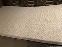 Top view of foam single bed mattress showing textured diamond pattern and overall condition