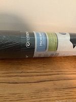 Photo showing the packaging label of a rolled-up black yoga mat with Renew brand and Microban antimicrobial protection sticker.