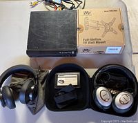 Full TV mount box, DVD player, Bose QC2 headphones in case plus Bluedio wireless headphones with pouch.