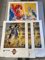 Five prints on a floor including three Leroy Neiman Juan Marichal tribute prints and one large Mark McGuire signed print, showing full lot overview.