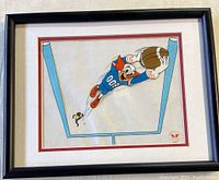 Framed Bozo animation cel showing full view with black frame, white and red matte, featuring Bozo in a blue uniform catching a football inside goal posts.