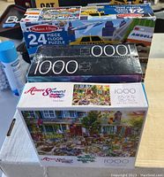 Three puzzles stacked showing two sealed 1000-piece puzzles and a Melissa & Doug floor puzzle box