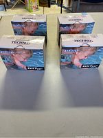 Four Techno Safe Pool security alarms in original boxes, arranged in a square on table surface