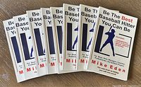 Ten copies of the book "Be The Best Baseball Hitter You Can Be" by Mike Eden, arranged in a fan shape showing the front covers.
