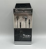Front view of unopened Mental Beats Icon Fidelity earbuds packaging showing earbuds, audio jack, and in-line microphone visible through clear plastic window.