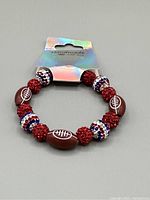 Front view of the handmade football-themed beaded bracelet on display card.