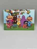 Photo of a vintage 1978 McDonald's postcard featuring various classic McDonald's characters.