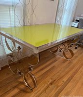 Side angle showing lime green acrylic top with thick clear acrylic edges and ornate gold accents on the clear acrylic base.