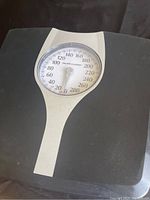 Photo showing the black Health o Meter analog bathroom scale with a round dial displaying weight in pounds up to 280.