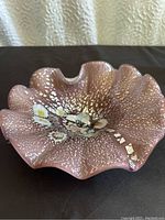 Top-down view of Murano glass bowl showing ruffled edges, silver flecks, and millefiori pattern in center.