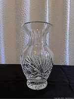 Front view of clear crystal vase showing cut starburst and geometric pattern.