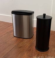 Side view showing stainless steel trash can and black metal storage container