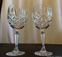 Front view of two Waterford crystal wine glasses with diamond-cut designs on the bowls and slender stems.
