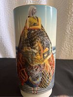 Close-up side view of the West Elm Mariner vase showing the blonde woman holding multi-colored fishing nets with ocean background.