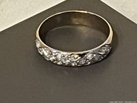 Ring displayed flat on dark background showing top cluster of diamonds
