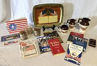 Overview of the lot showing tray, stoneware, rocks glasses, books, pamphlets, and key ring