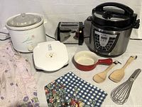 Overview of entire kitchen item set arranged on white surface including appliances and utensils