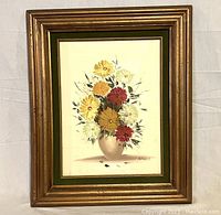 Frontal image of floral oil painting with bouquet of burgundy, gold, and white flowers in a vase, signed by Angela, framed in gilded wood with green velvet matte.