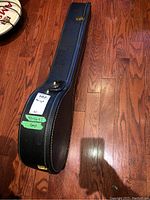Closed black vinyl-covered banjo case on wood floor