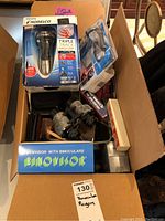 Box with assorted items including Philips Norelco shaver, binoculars, and various electronics.