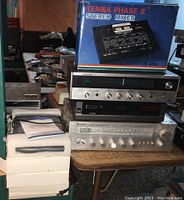 Stack of vintage electronics including the Tenna Phase 3 stereo mixer box on top, several receivers stacked underneath, and digital satellite receiver to the side.