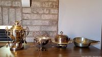 Full view of all four items: silverplated sugar bowl with spoons, pedestal condiment bowl, domed butter dish, pewter saucepan
