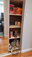 Shelf unit with multiple toiletry products including boxed skincare sets, lotion, and soaps