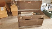 Wide photo of brown metal Kennedy Kits tool box open showing various tools inside including rulers and tool case