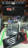 Multiple tool sets including drill bits, socket sets, Mastercraft pliers and wrenches, offset ratchet set and soldering tool kit displayed with the tool box.