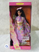 Front view of the boxed 1995 Japanese Barbie doll showcasing the doll wearing a traditional kimono with pink and purple floral patterns, inside original box with clear front panel.