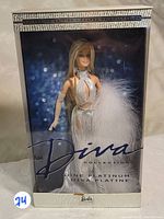 Front view of boxed Barbie doll in silver Diva Collection gown, showing packaging and branding.