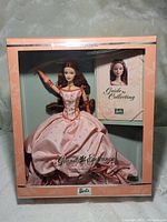 Front view of Birthday Wishes Barbie doll in original pink packaging showing the doll in a pink ball gown and collector's guide booklet.