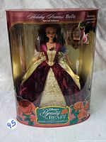 Front view of the boxed Disney Enchanted Holiday Princess Belle Barbie Doll, showing the doll in elegant burgundy and gold gown with floral designs on the box.