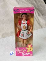 Front view of 1997 Holiday Treats Christmas Barbie doll in original box showing the Barbie doll inside clear plastic window and the pink themed holiday packaging with gingerbread men design.