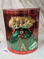 Front view of Barbie doll in original red packaging with green holiday dress and holiday greetings on box.