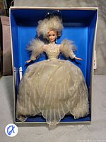 Full view of the Snow Princess Barbie doll in original box showing white and gold gown and feathered headpiece.