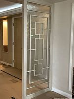 Full height view of glass panel showing frame and geometric lattice pattern