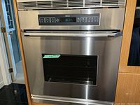 Front view of stainless steel oven installed in cabinetry, control panel visible