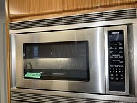 Front exterior view showing stainless steel door, integrated vent, and digital control panel on right.