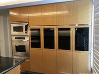 Front view of full wall of bamboo cabinetry with black glass and stainless steel microwave/oven area (oven and microwave not included)