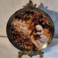 Front view showing detailed illustration of girl decorating Christmas tree and gold ornate rim.