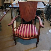 Front view of the solid mahogany wooden armchair showing the upholstered striped seat and curved armrests.