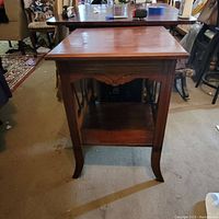 Front view of vintage Ferguson Liure mahogany side table showing rectangular top, front panel with lyre design, shelf, and curved legs.