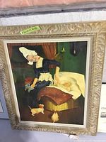 Full view of the framed oil painting showing a woman dressed in traditional attire leaning over a baby in a basket, with two chicks on the floor and green walls in background.