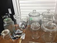 Overview of all glass canisters arranged on table, showing different sizes and lid types