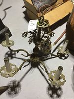 Full overhead view of brass chandelier showing five arms and wiring.