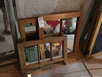 Three wood framed mirrors arranged together on floor, visible wooden frames with glass reflecting surroundings