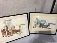 Two framed street scene watercolors side by side