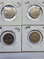 Four 1948 Canadian 5 cent coins in coin holders with date and weight labeling, displayed on a flat surface.